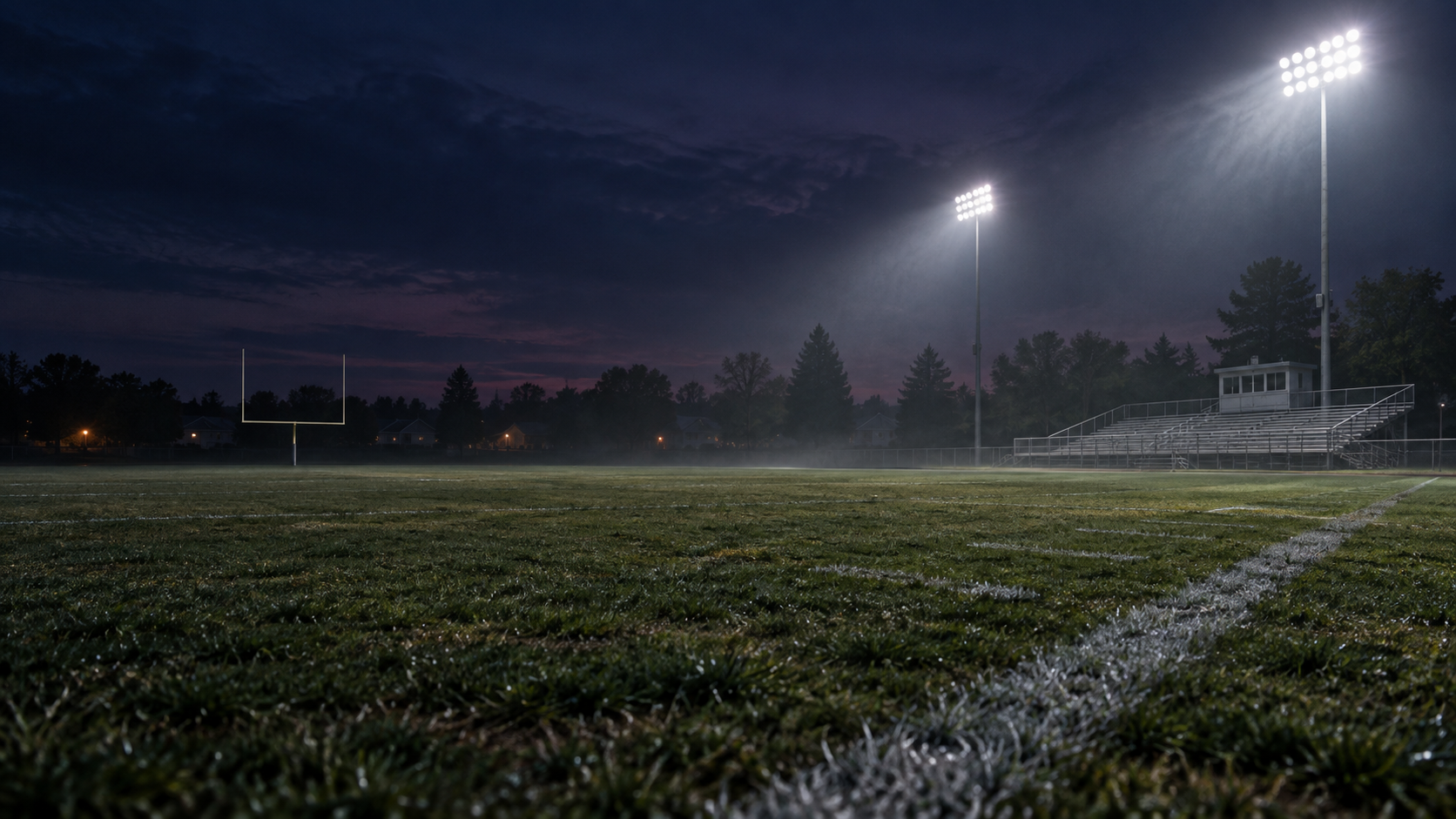 Floodlights illuminate the LARPers municipal football field at dusk
